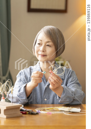 水引で髪飾りを作るシニア女性 水引で髪飾りを作るシニア女性 139869116