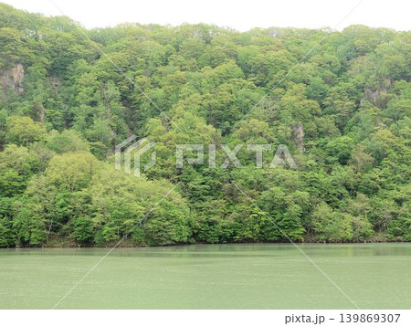 新緑の山肌と静かな湖面の自然風景 139869307