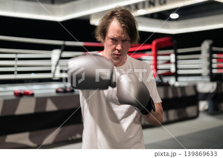 Male Boxer Punching Toward Camera in Boxing Ring 139869633