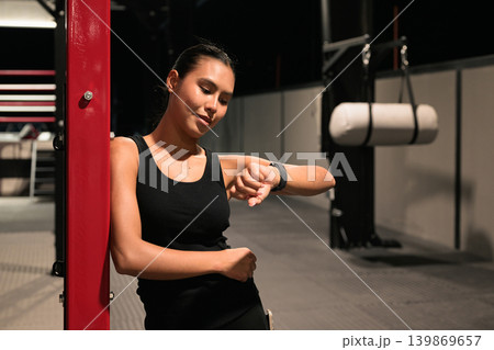 Horizontal Shot of Female Athlete Checking Smartwatch in Gym Horizontal Shot of Female Athlete Checking Smartwatch in Gym 139869657