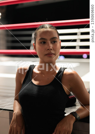 Vertical Portrait of Female Athlete Looking Away by Boxing Ring Vertical Portrait of Female Athlete Looking Away by Boxing Ring 139869660