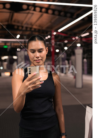 Female Athlete Using Smartphone in Vertical Shot Female Athlete Using Smartphone in Vertical Shot 139869826
