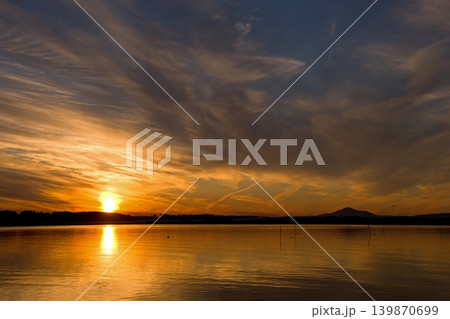 茨城県、涸沼の夕景。オレンジ色に輝く太陽と雲にシルエットの筑波山が印象的で綺麗だ。 茨城県、涸沼の夕景。オレンジ色に輝く太陽と雲にシルエットの筑波山が印象的で綺麗だ。 139870699