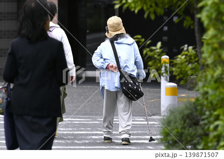 日本の横浜都市景観 腰を曲げた杖の高齢女性。横断中…左隣に優しそうな女性が同伴=横浜市内で 日本の横浜都市景観 腰を曲げた杖の高齢女性。横断中…左隣に優しそうな女性が同伴=横浜市内で 139871507