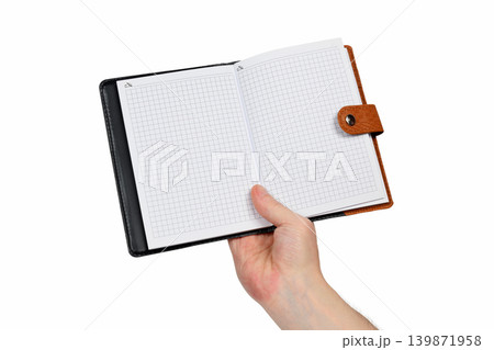 hand holding an open checkered notebook isolated on a white background hand holding an open checkered notebook isolated on a white background 139871958