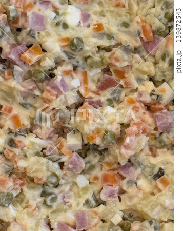 Olivier salad with diced vegetables and meat in a creamy dressing, ideal for background or recipe Olivier salad with diced vegetables and meat in a creamy dressing, ideal for background or recipe 139872543