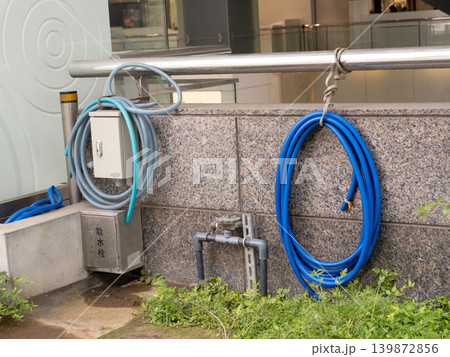 ビルの植栽の散水栓とホース 139872856