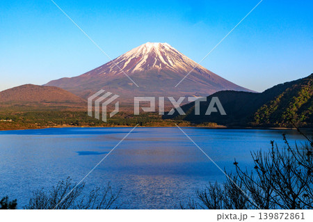 春の山梨県の美しい本栖湖と少し赤い富士山と青空 139872861