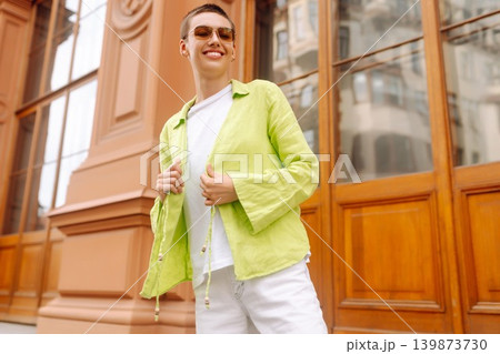 Stylish young woman with short haircut posing on city streets. The concept of fashion, style. 139873730