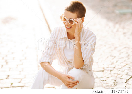 Beautiful woman in stylish clothes and short hair poses. Minimalism, urban style clothes. Beautiful woman in stylish clothes and short hair poses. Minimalism, urban style clothes. 139873737