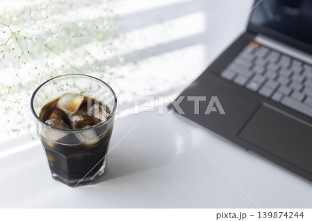 アイスコーヒーとノートパソコンのあるシンプルなワークスペース アイスコーヒーとノートパソコンのあるシンプルなワークスペース 139874244