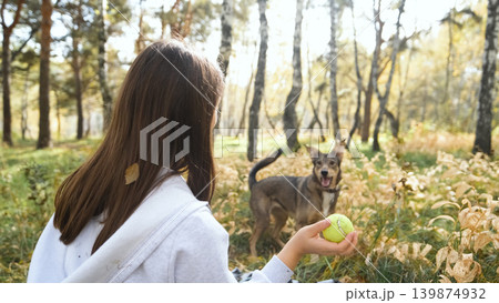 Young woman walking with a dog in an autumn forest Young woman walking with a dog in an autumn forest 139874932
