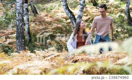 A young man and a girl in love are walking in an autumn park on a sunny autumn day. A young man and a girl in love are walking in an autumn park on a sunny autumn day. 139874960
