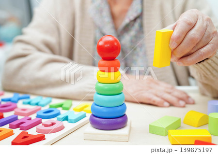 Asian elderly woman playing game. 139875197