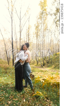 Married couple relaxing in nature during a walk in the autumn forest. Woman and man in love walking through tall yellow grass, in fern leaves Married couple relaxing in nature during a walk in the autumn forest. Woman and man in love walking through tall yellow grass, in fern leaves 139875418
