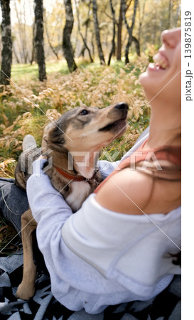 Young woman walking with a dog in an autumn forest 139875819