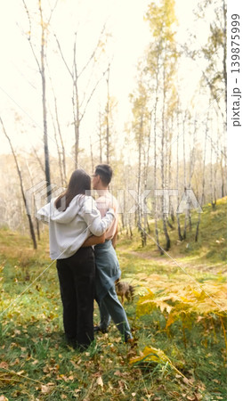 Married couple relaxing in nature during a walk in the autumn forest. Woman and man in love walking through tall yellow grass, in fern leaves Married couple relaxing in nature during a walk in the autumn forest. Woman and man in love walking through tall yellow grass, in fern leaves 139875999
