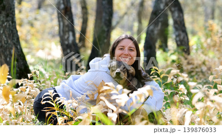 Young woman walking with a dog in an autumn forest Young woman walking with a dog in an autumn forest 139876033