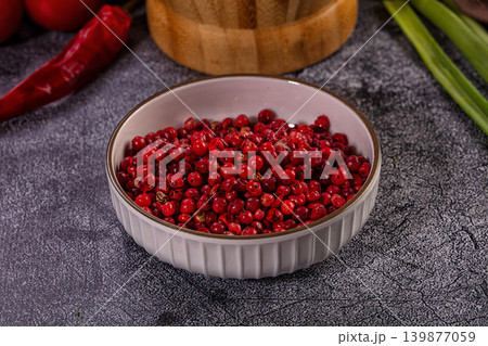 Vibrant Red Pink Peppercorns in Ceramic Bowl on Grey Background Vibrant Red Pink Peppercorns in Ceramic Bowl on Grey Background 139877059