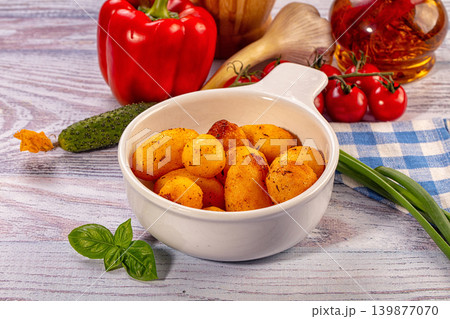 Roasted new potatoes with herbs and fresh vegetables on rustic wooden table Roasted new potatoes with herbs and fresh vegetables on rustic wooden table 139877070