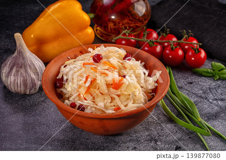 Sauerkraut salad in rustic clay bowl with fresh vegetables like tomatoes, garlic, and pepper Sauerkraut salad in rustic clay bowl with fresh vegetables like tomatoes, garlic, and pepper 139877080