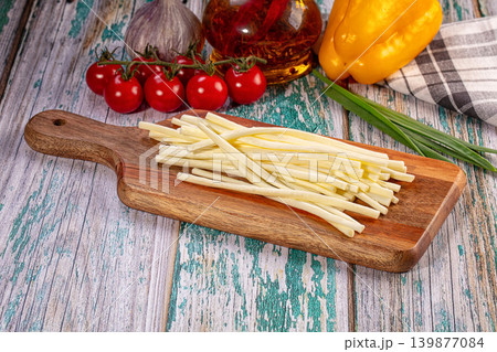 Braided string cheese with fresh vegetables on rustic wooden table 139877084