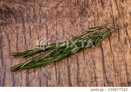 Fresh rosemary sprigs on rustic wooden background Fresh rosemary sprigs on rustic wooden background 139877102