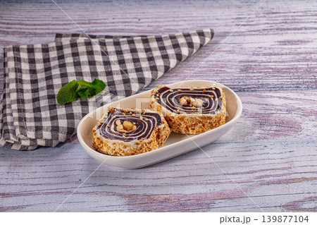 Turkish delight roll with sesame seeds and peanuts in white bowl on rustic wooden table Turkish delight roll with sesame seeds and peanuts in white bowl on rustic wooden table 139877104