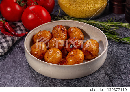 Roasted baby potatoes in savory glaze with fresh tomatoes and rosemary 139877110