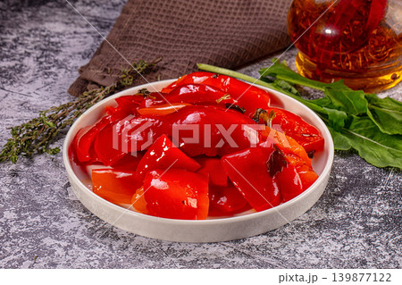 Roasted red bell peppers in oil with fresh herbs in white bowl Roasted red bell peppers in oil with fresh herbs in white bowl 139877122