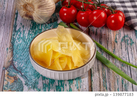 Pickled ginger in ceramic bowl with fresh garlic and tomatoes on rustic wooden table Pickled ginger in ceramic bowl with fresh garlic and tomatoes on rustic wooden table 139877183