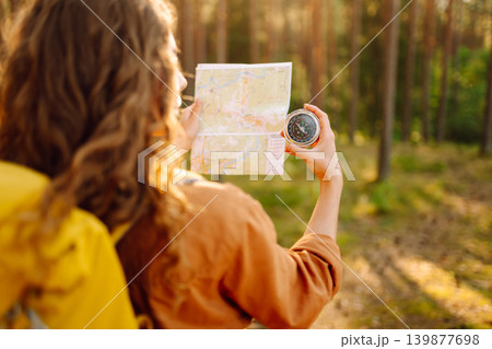 Traveler young woman searching direction with compass on background of map in the forest. Adventure 139877698