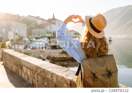 Woman tourist holding hands in shape of heart looking at panoramic landscape of city. Lifestyle. Woman tourist holding hands in shape of heart looking at panoramic landscape of city. Lifestyle. 139878122