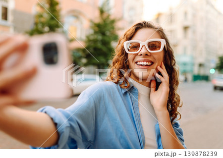 Beautiful woman traveler using phone, taking selfie, walking on the old town street. Blogging 139878239