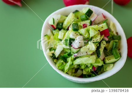 healthy organic salad with fresh spring vegetables on green background 139878416
