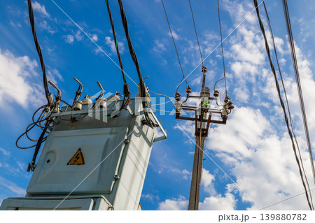 Electrical Transformer and Power Lines Against Blue Sky Electrical Transformer and Power Lines Against Blue Sky 139880782