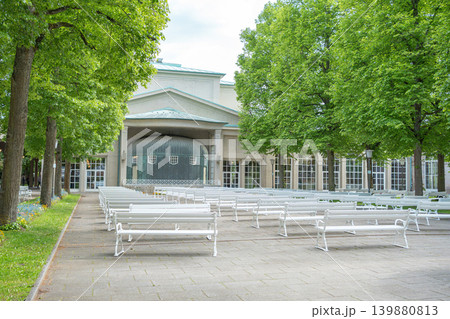 Well-maintained park zone with seating places and classical architecture in the background. Concept of urban landscaping, tourism, and outdoor recreation. 139880813