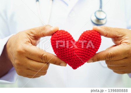 Asian woman doctor holding red heart for health in hospital. Asian woman doctor holding red heart for health in hospital. 139880888