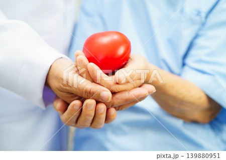 Asian elder senior woman patient holding red heart in hospital. 139880951