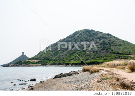 岩の海岸線と海岸脇の緑に囲まれた小さな小山 地中海に浮かぶフランス領のコルシカ島にて 岩の海岸線と海岸脇の緑に囲まれた小さな小山 地中海に浮かぶフランス領のコルシカ島にて 139881019