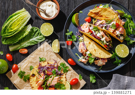 salmon tacos drizzled with sauce on a plate salmon tacos drizzled with sauce on a plate 139881271