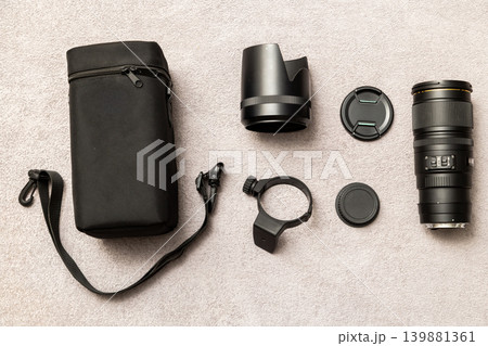Camera Lens and Accessories Flat Lay on Grey Surface 139881361