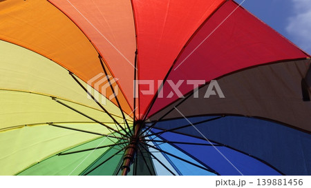 Rainbow umbrella close-up against blue sky 139881456