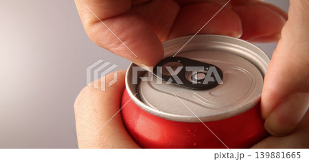 Cola or soda can opening. Close up of hand open aluminum beverage can with pull tab. Refreshing Cola or soda carbonated soft drink container with metal texture condensation droplets and easy open lid Cola or soda can opening. Close up of hand open aluminum beverage can with pull tab. Refreshing Cola or soda carbonated soft drink container with metal texture condensation droplets and easy open lid 139881665