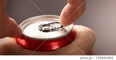 Cola or soda can opening. Close up of hand open aluminum beverage can with pull tab. Refreshing Cola or soda carbonated soft drink container with metal texture condensation droplets and easy open lid Cola or soda can opening. Close up of hand open aluminum beverage can with pull tab. Refreshing Cola or soda carbonated soft drink container with metal texture condensation droplets and easy open lid 139881668