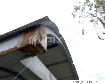 Metal Canopy Construction Showing Rust and Wear Near a Tree 139882130