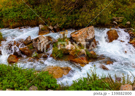 Fast flowing mountain river cascades over rocks in wilderness in Kyrgyzstan Fast flowing mountain river cascades over rocks in wilderness in Kyrgyzstan 139882800