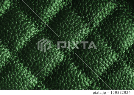 Macro of green quilted leather texture background with stitched pattern and shining metal effect Macro of green quilted leather texture background with stitched pattern and shining metal effect 139882924