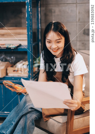Female artist wears black hat posing near picture indoor the studio 139883092