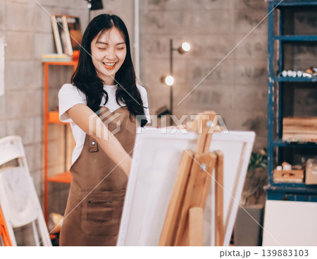 Female artist wears black hat posing near picture indoor the studio Female artist wears black hat posing near picture indoor the studio 139883103